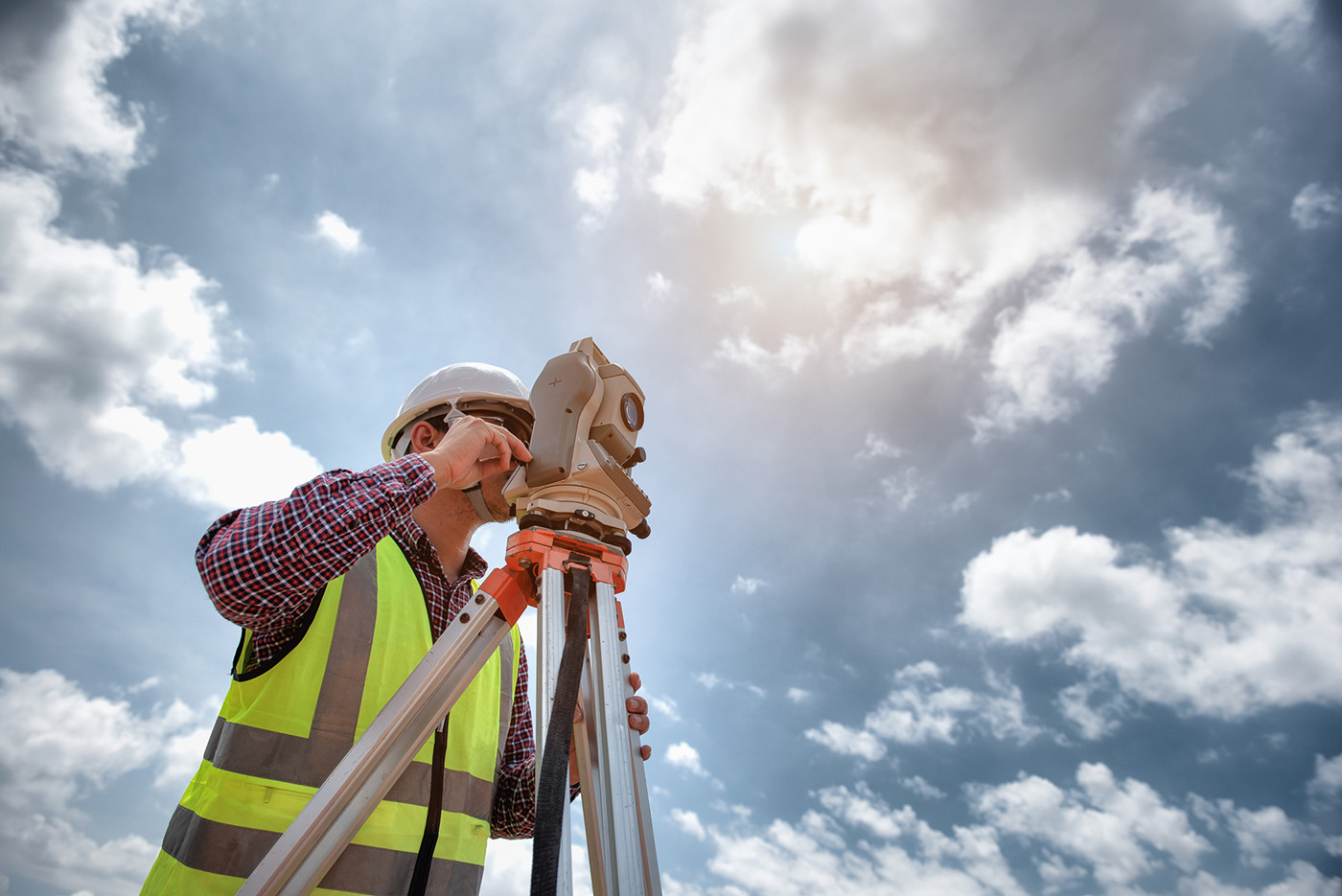 Surveyor Engineering. Surveyor Using Telescope At Construction Site, Surveying For Making Contour Plans Are A Graphical Representation Of The Lay Of The Land Before Startup Construction Work.